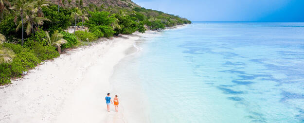 couple walking on a beach in Fiji