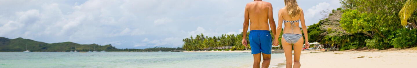 Couple walking on beach at Lomani Fiji