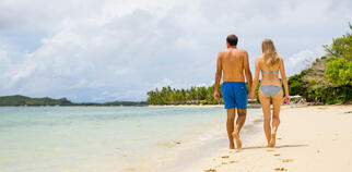 Couple walking on beach at Lomani Fiji