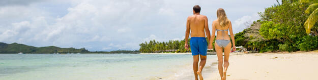 Couple walking on beach at Lomani Fiji