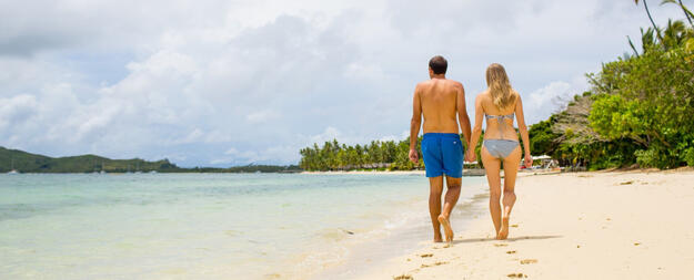 Couple walking on beach at Lomani Fiji