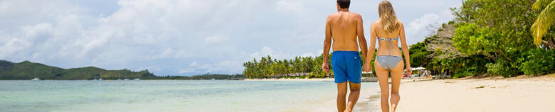 Couple walking on beach at Lomani Fiji