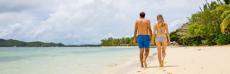 Couple walking on beach at Lomani Fiji