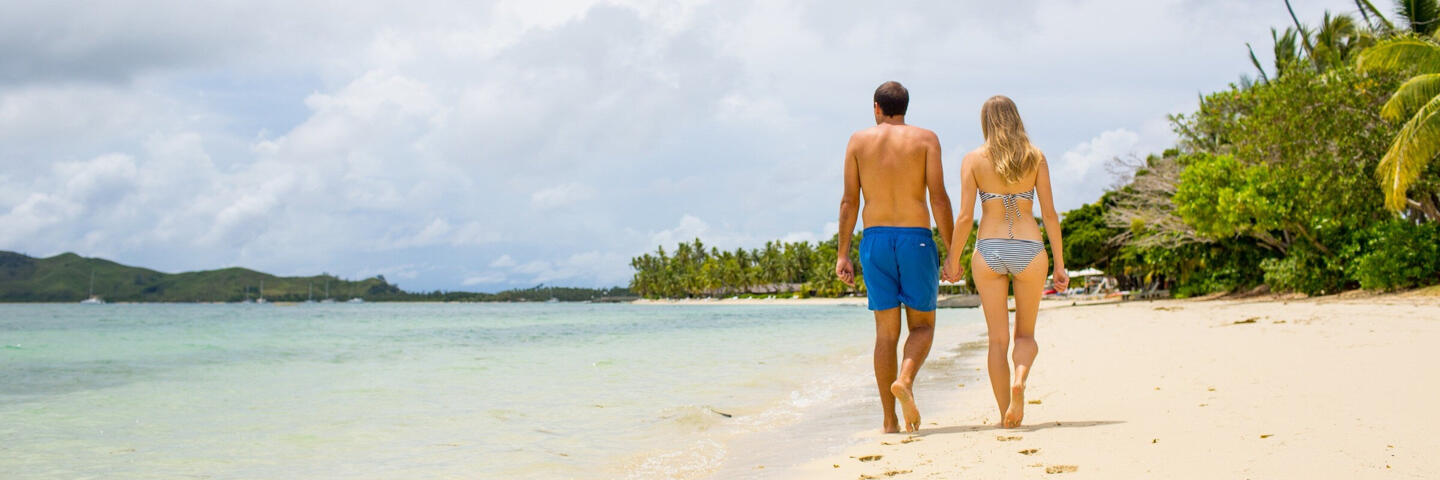 Couple walking on beach at Lomani Fiji