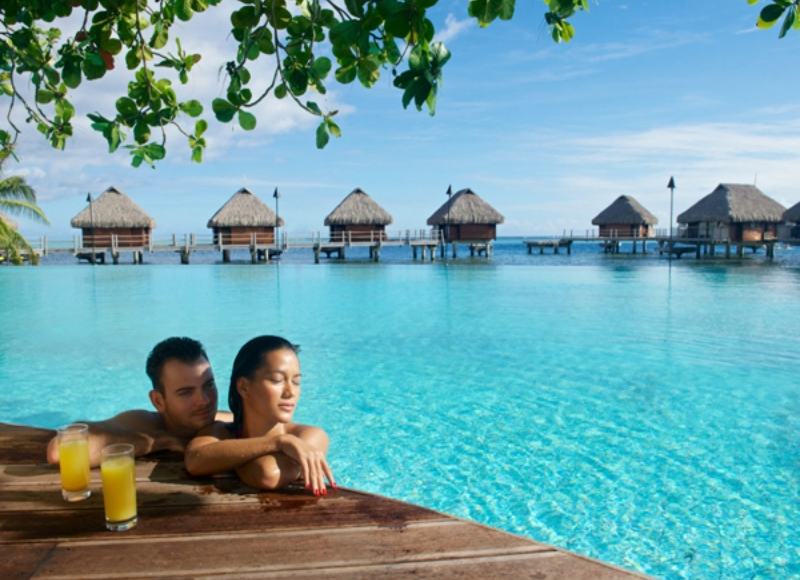 Couple with overwater bungalows in the background