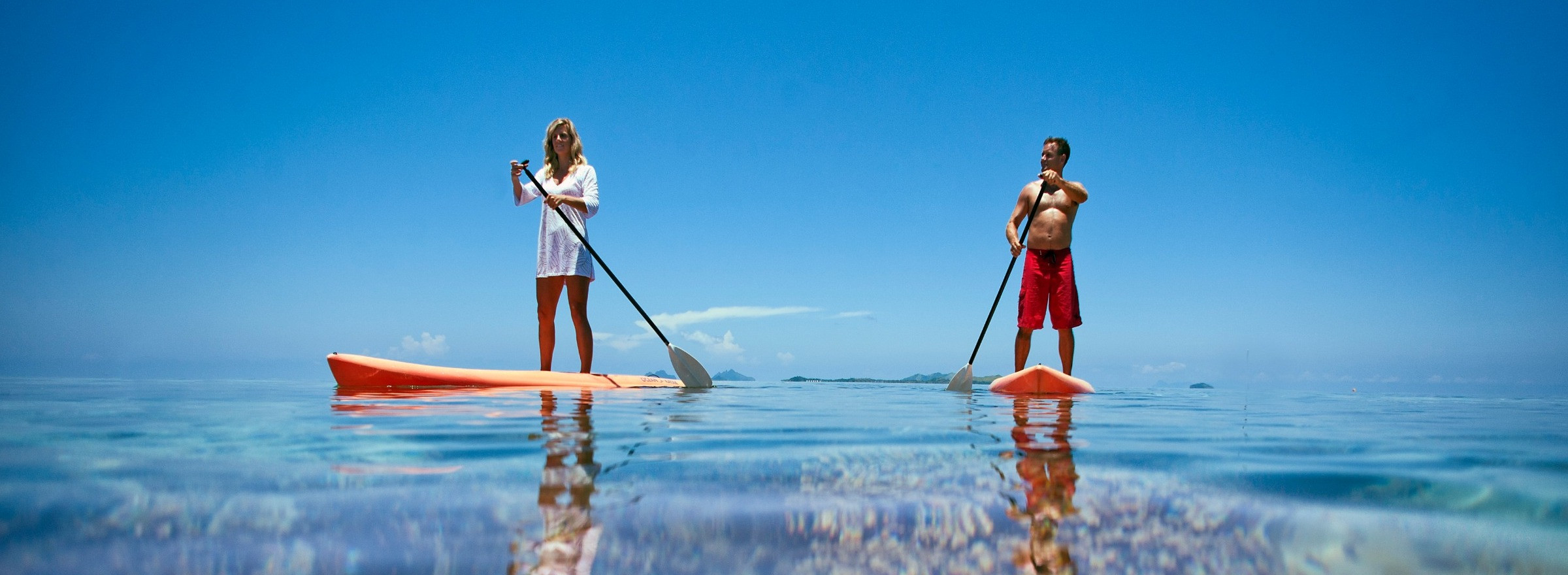 Image of a man and woman on stand up paddle boards