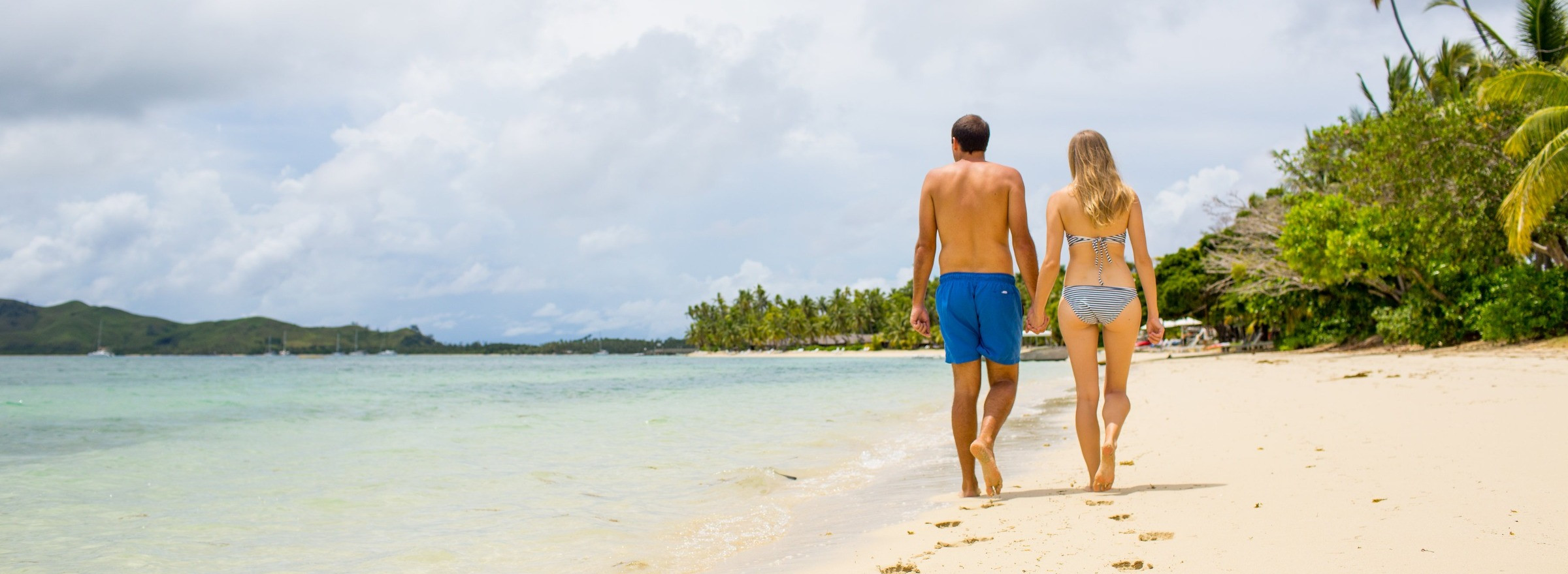 Couple walking on beach at Lomani Fiji